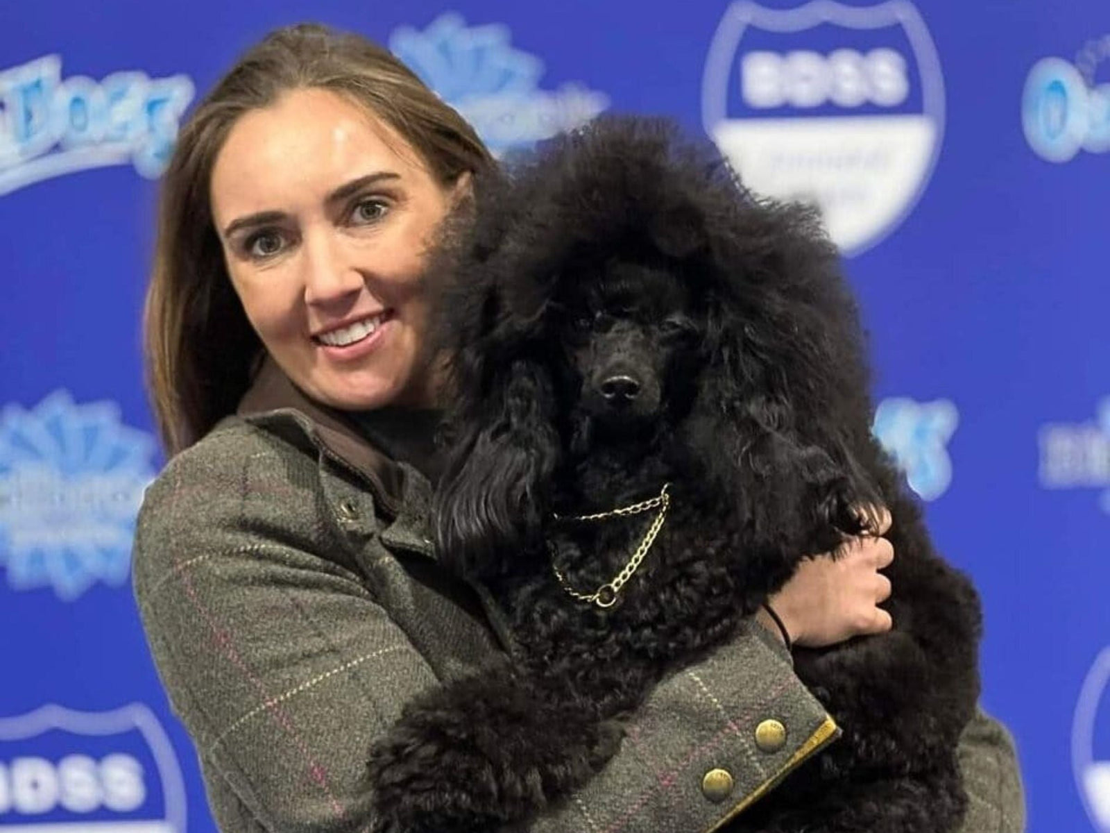 Zara Leech holding her beautiful black miniature show poodle Laci at the dog show