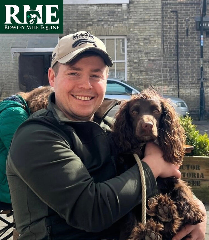 Vet Gregor Hepburn smiling with his brown spaniel